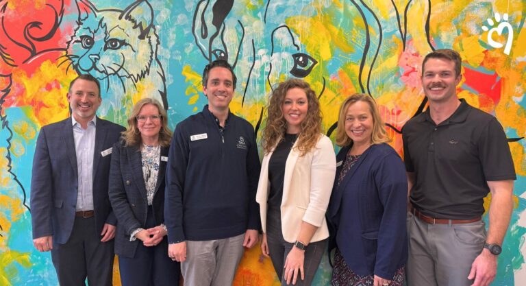 a group of people standing in front of a colorful wall