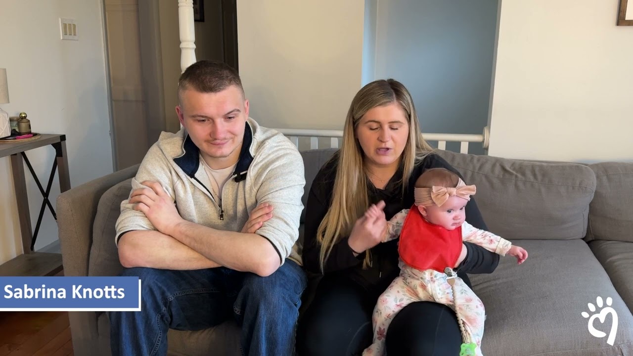 a man and woman sitting on a couch with a baby