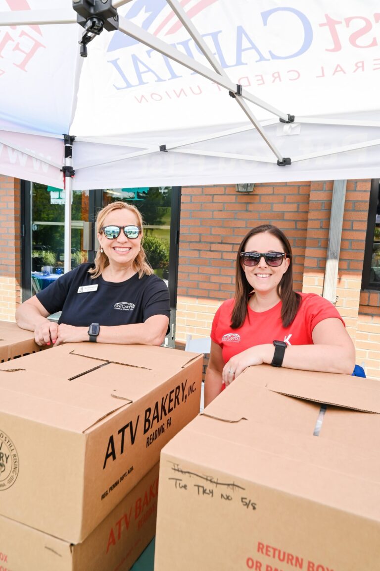 a couple of women standing under a tent with boxes