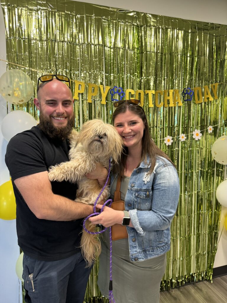 a man and woman holding a dog