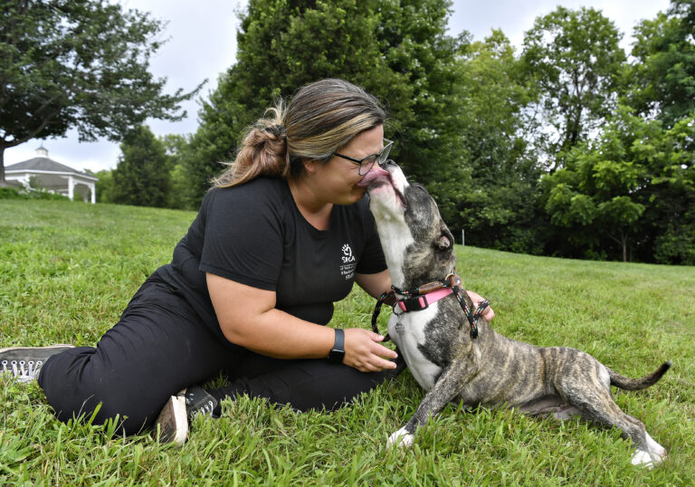 photo of woman kissing dog