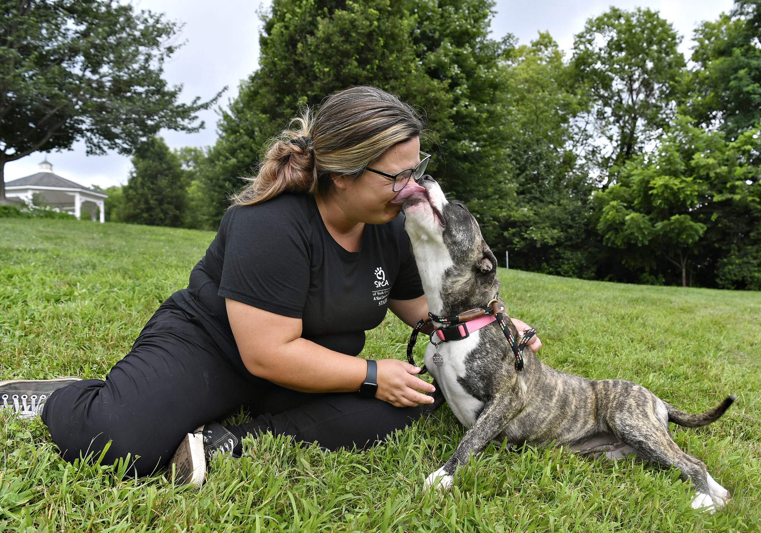 photo of woman kissing dog