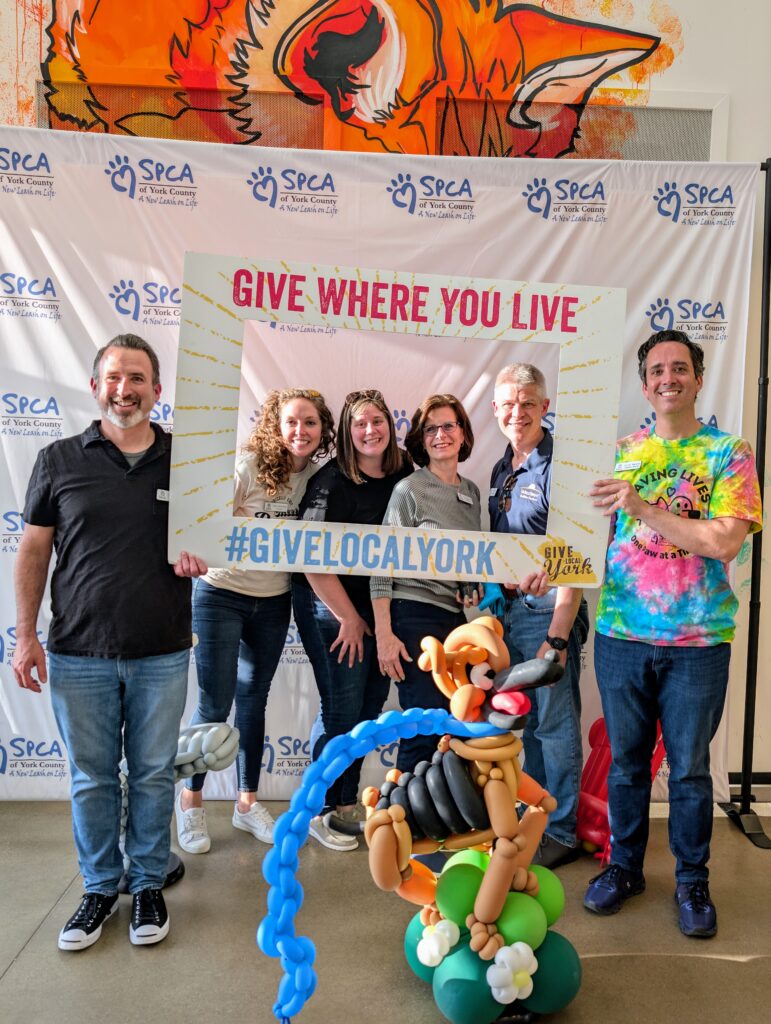 Group photo with balloon sculpture backdrop.
